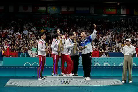Players of South, North Korea and China takes a selfie during medal ceremony